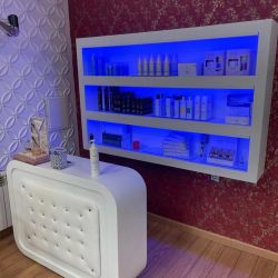 Mostrador blanco con estantería iluminada